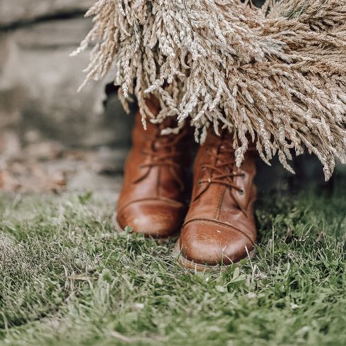 Lederschuhe auf Rasen mit einen Gräserkranz